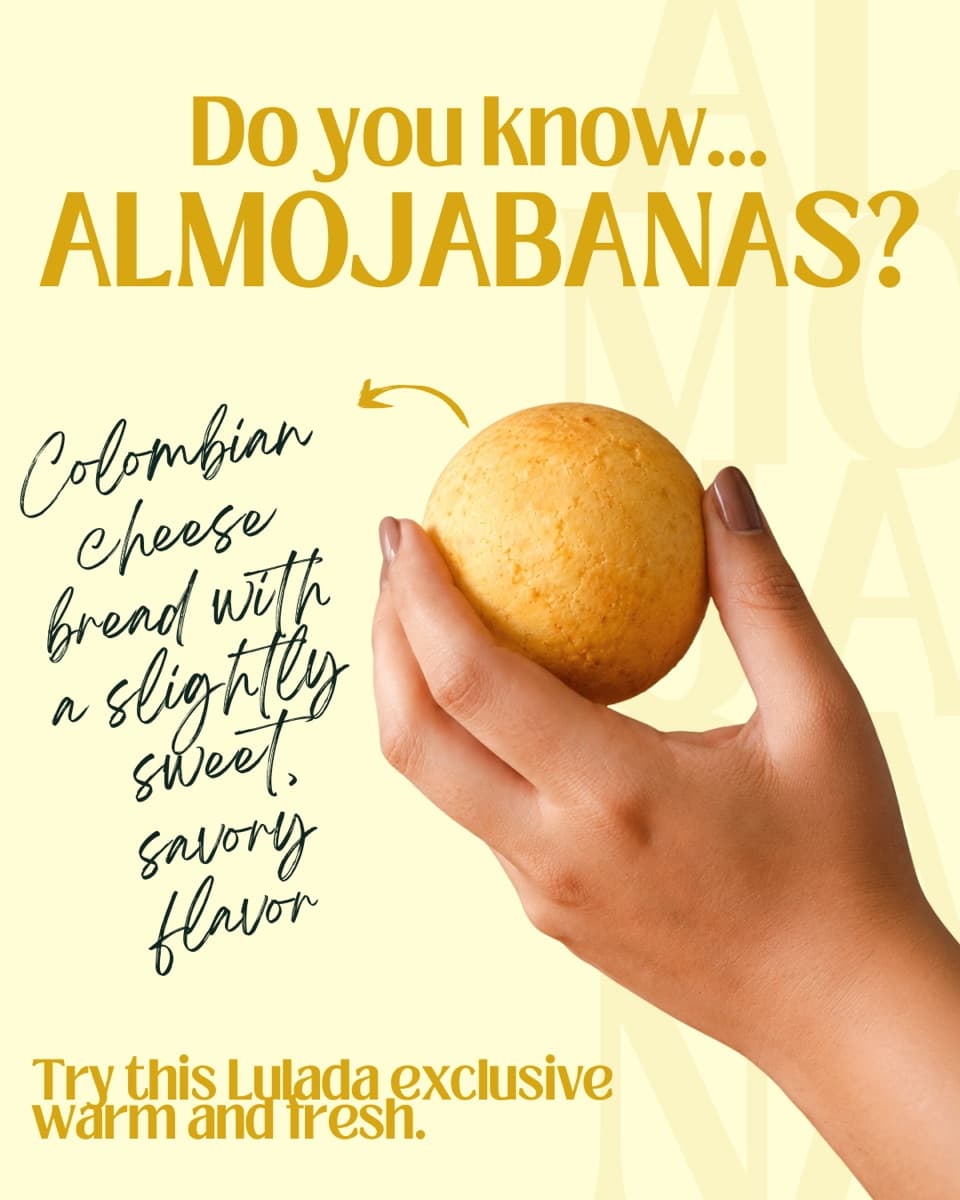 A hand holding a warm Colombian almojábana, a slightly sweet cheese bread.